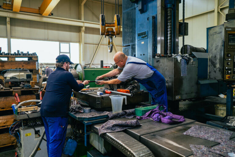 Zwei Techniker der Eicken Maschinenbau-Service GmbH beim Retrofitting einer Werkzeugmaschine in einer Fertigungshalle in Aschersleben