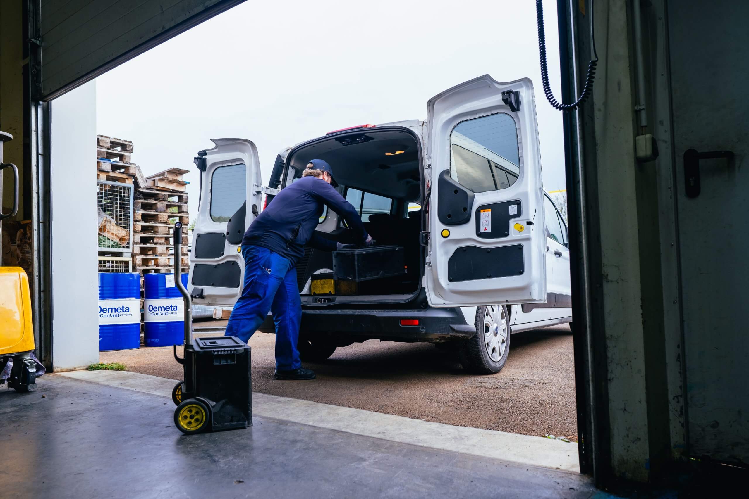 Ein Servicetechniker lädt Werkzeugkisten in ein Firmenfahrzeug am Hallentor, bei einem Maschinenbau Unternehmen Aschersleben.